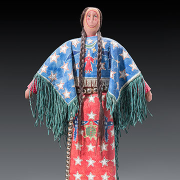 a Native American doll with beaded clothing and two long braids